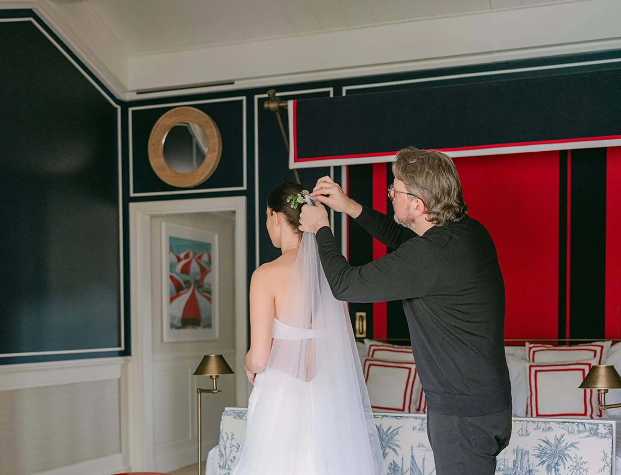 Coiffeur ajustant le voile d'une mariée dans une chambre au design moderne de l'hôtel AREV de Saint-Tropez.