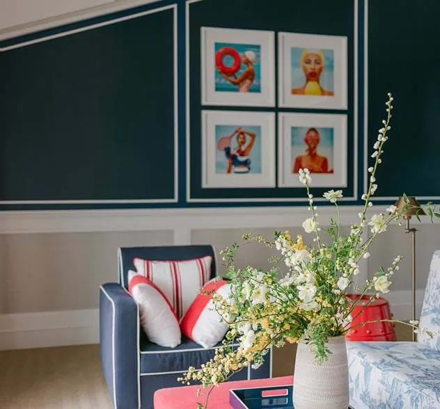 O AREV Hotel Saint-Tropez apresenta um design interior elegante com uma poltrona azul, detalhes em vermelho e flores frescas.