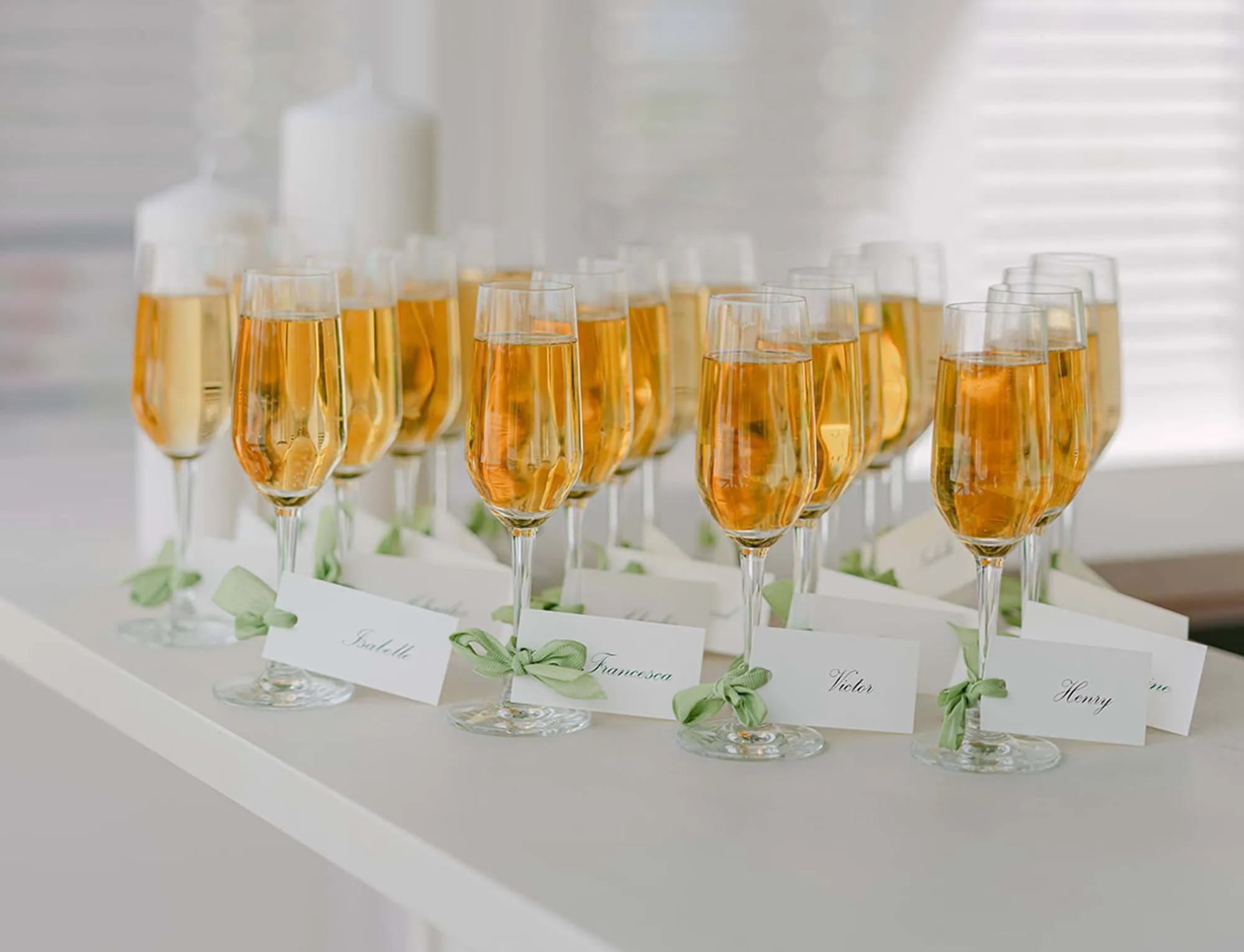Fila de taças de champanhe com cartões personalizados para uma recepção de boas-vindas no AREV Saint-Tropez.