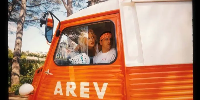 Van vintage retro laranja e branco com a marca AREV hotel em Saint-Tropez, adicionando um toque vintage lúdico à propriedade.