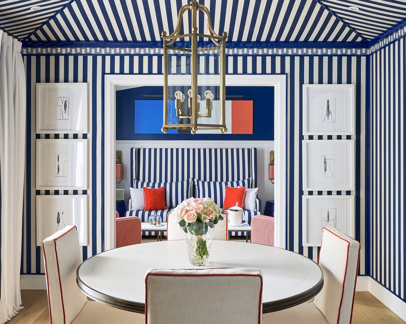 Design interior de luxo com listras azuis e brancas com detalhes em vermelho no hotel AREV em Saint-Tropez.