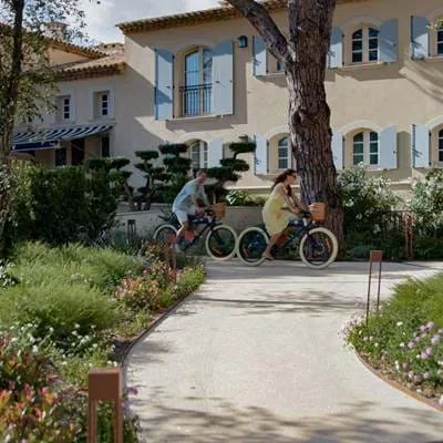 Gäste radeln durch die üppigen mediterranen Gärten des Hotels AREV in Saint-Tropez.