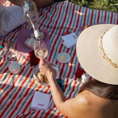 Romantisches Picknick mit Roséweinverkostung auf einer gestreiften Decke im Hotel AREV in Saint-Tropez.
