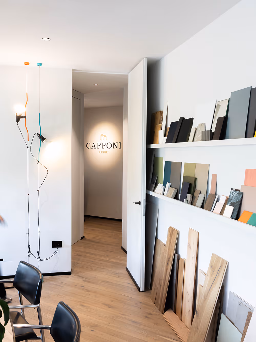 interno degli uffici Capponi Group con parete brandizzata e lampada Parentesi di design