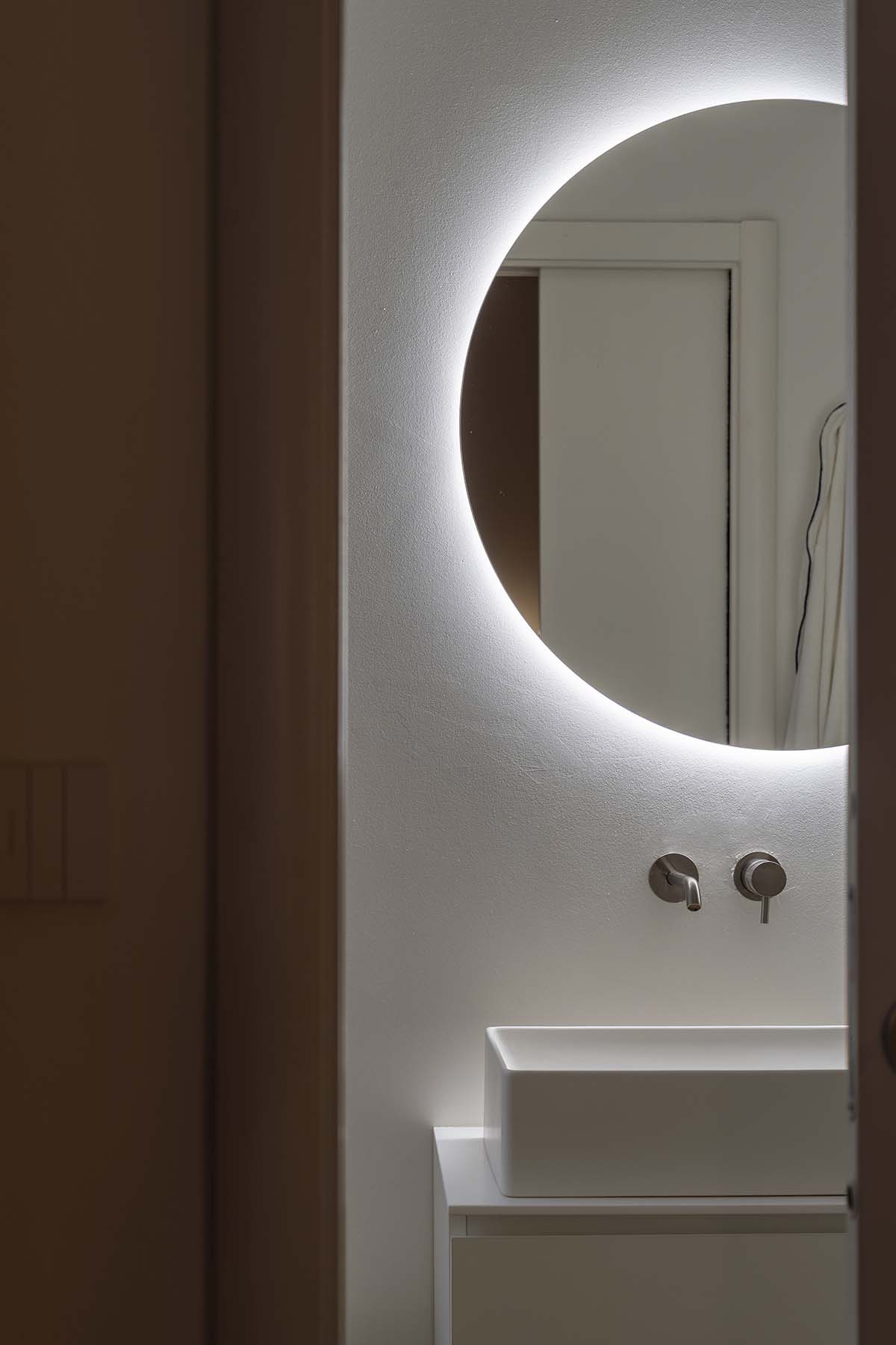 dettaglio specchio tondo in bagno contemporaneo in appartamento ristrutturato a Milano