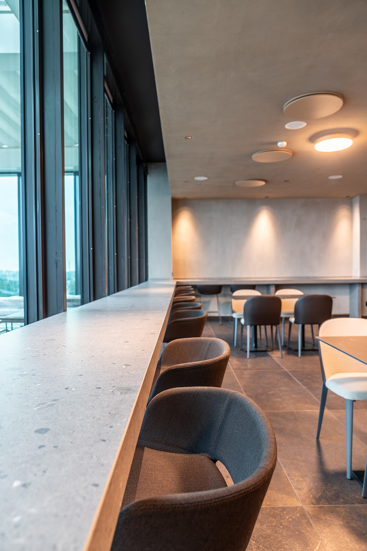 ambiente ristorante con luce naturale e materiali contemporanei in progetto di ristrutturazione a Bergamo