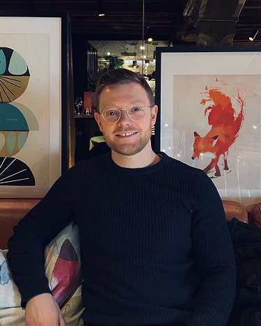 A man wearing a black turtle neck sweater.