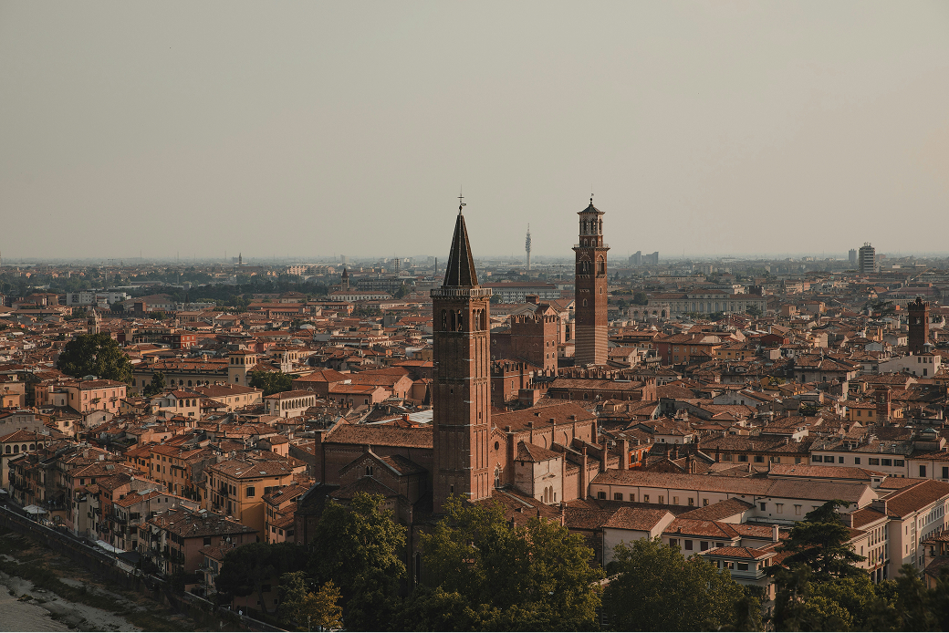 Veduta panoramica di Verona con il centro storico e le torri medievali al tramonto.