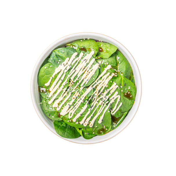 Ein frischer Spinatsalat in einer weißen Schüssel, beträufelt mit cremigem Dressing und bestreut mit Sesamkörnern, ergibt ein lebendiges und gesundes Gericht.