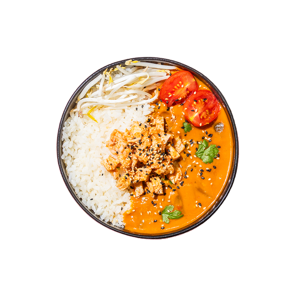 Eine Schüssel leuchtend orangefarbenes Curry mit Tofu, garniert mit Sesamsamen und Koriander. Dazu gibt es weißen Reis, Sojasprossen und Tomatenscheiben.