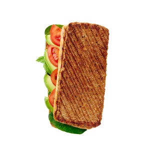 Gegrilltes Panini auf schwarzem Hintergrund mit sichtbaren Schichten aus frischem Salat, Tomatenscheiben und Avocado. Das Sandwich weist Grillstreifen auf, die auf Wärme hindeuten.