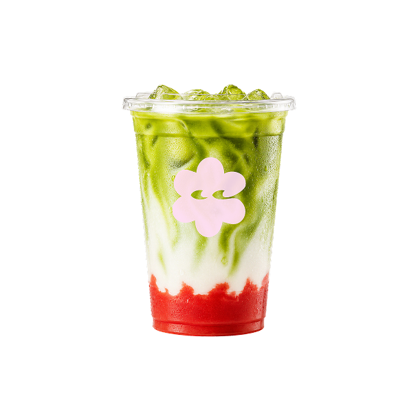 Ein durchsichtiger Kunststoffbecher mit einem geschichteten Matcha-Getränk aus grünem Tee, weißer Creme und rotem Erdbeerpüree, garniert mit einer rosa Blüte, vor schwarzem Hintergrund.