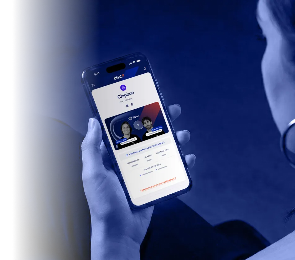 Une personne tenant un smartphone affichant une application d'investissement.