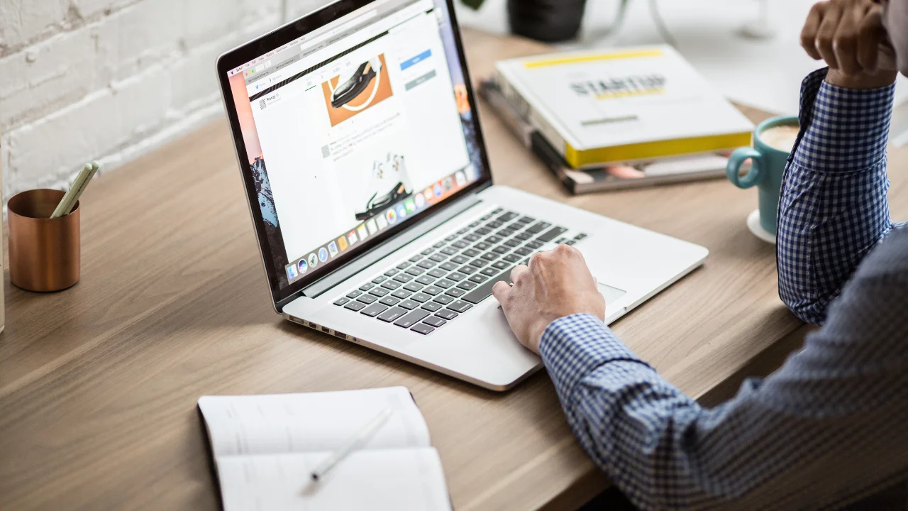Une personne consulte des informations sur son ordinateur, symbolisant la réflexion sur les risques liés à l'investissement dans une PME. Analyser ces risques est crucial pour prendre des décisions éclairées.