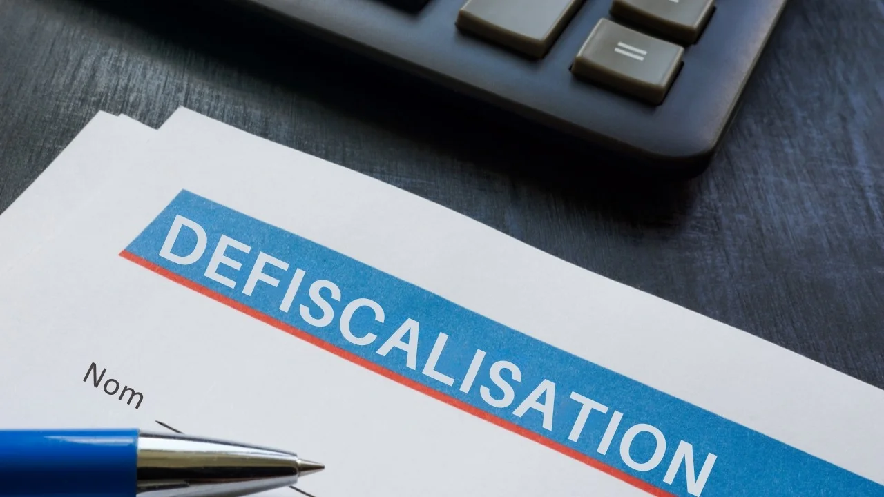 Un document de défiscalisation et une calculatrice illustrent les avantages de l'investissement dans une entreprise pour la défiscalisation.