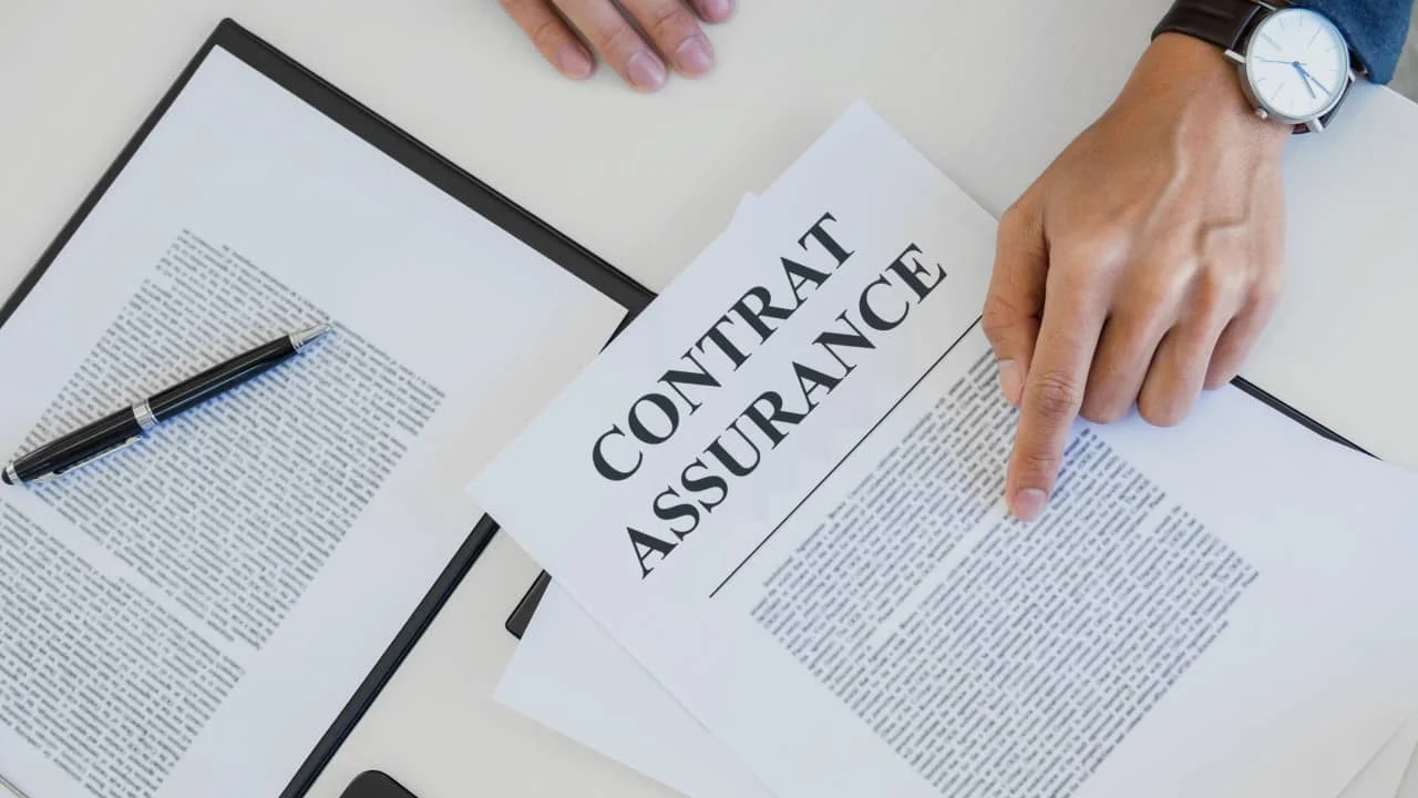 Image d'un contrat d'assurance posé sur un bureau, avec une main pointant du doigt un paragraphe du document, illustrant les principales tendances en Insurtech.