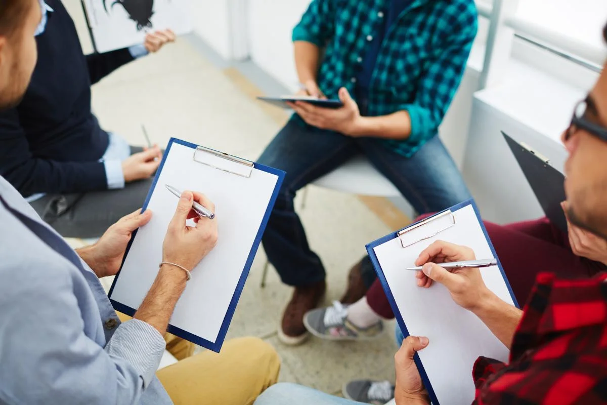 des personnes assisent sur des chaises et discutant du pacte d'associé