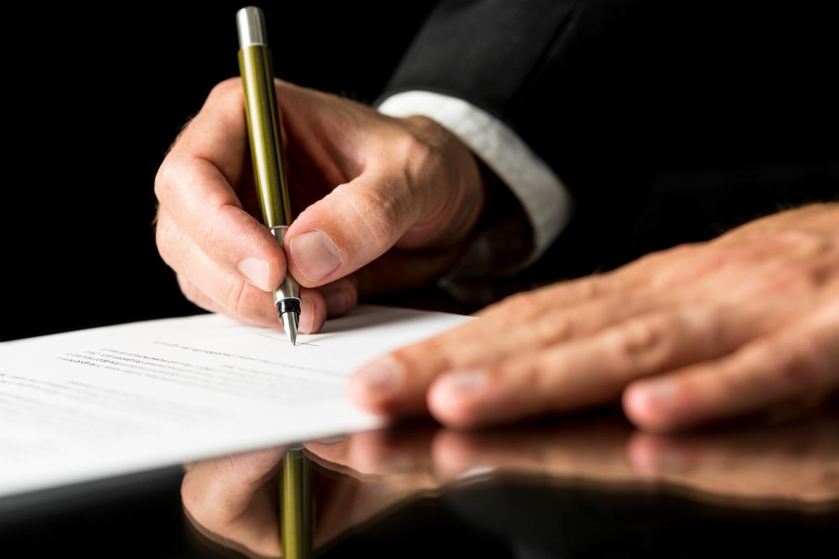 homme signant un pacte d'associé