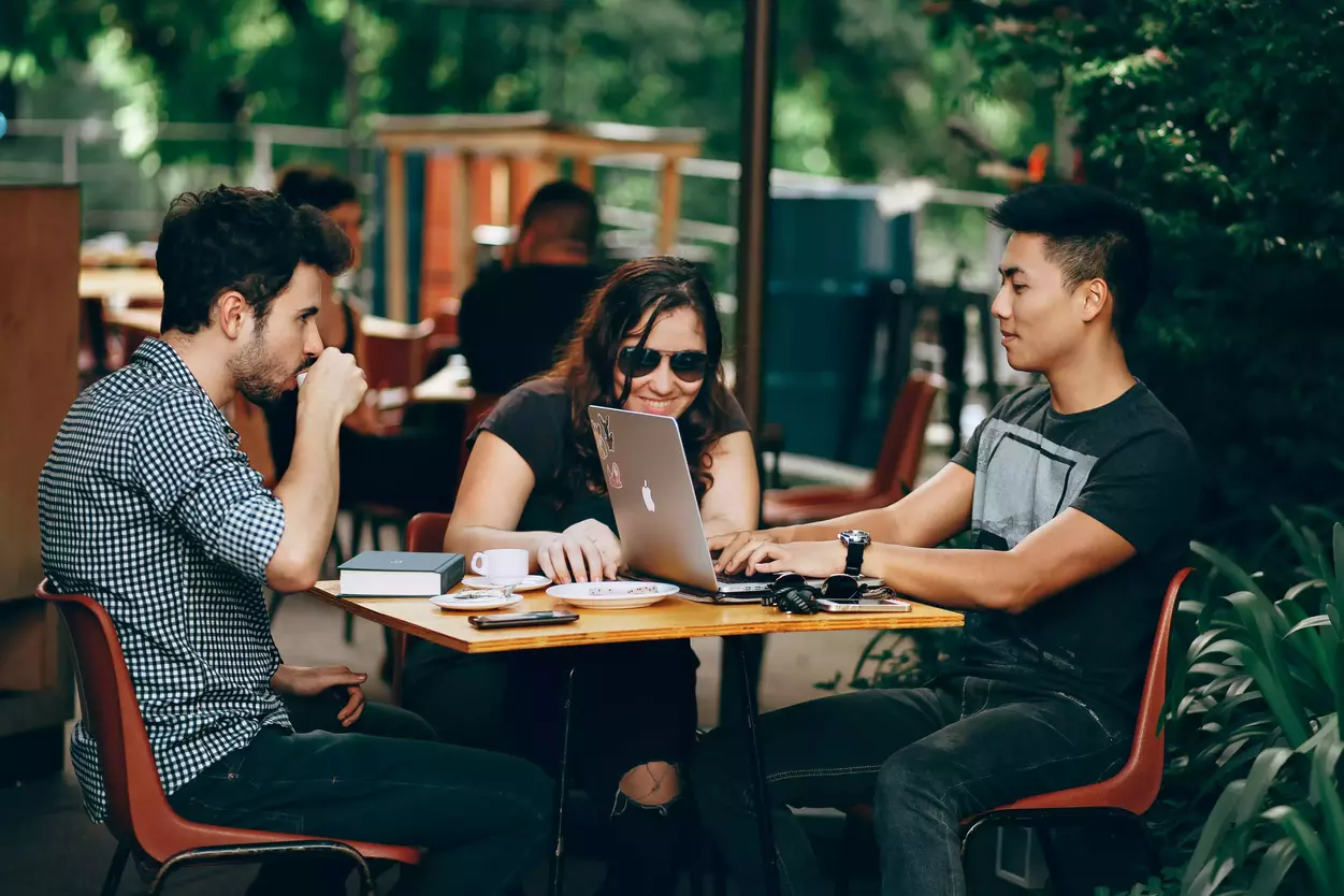 3 investisseurs discutant du private equity autour d'une table dans un café