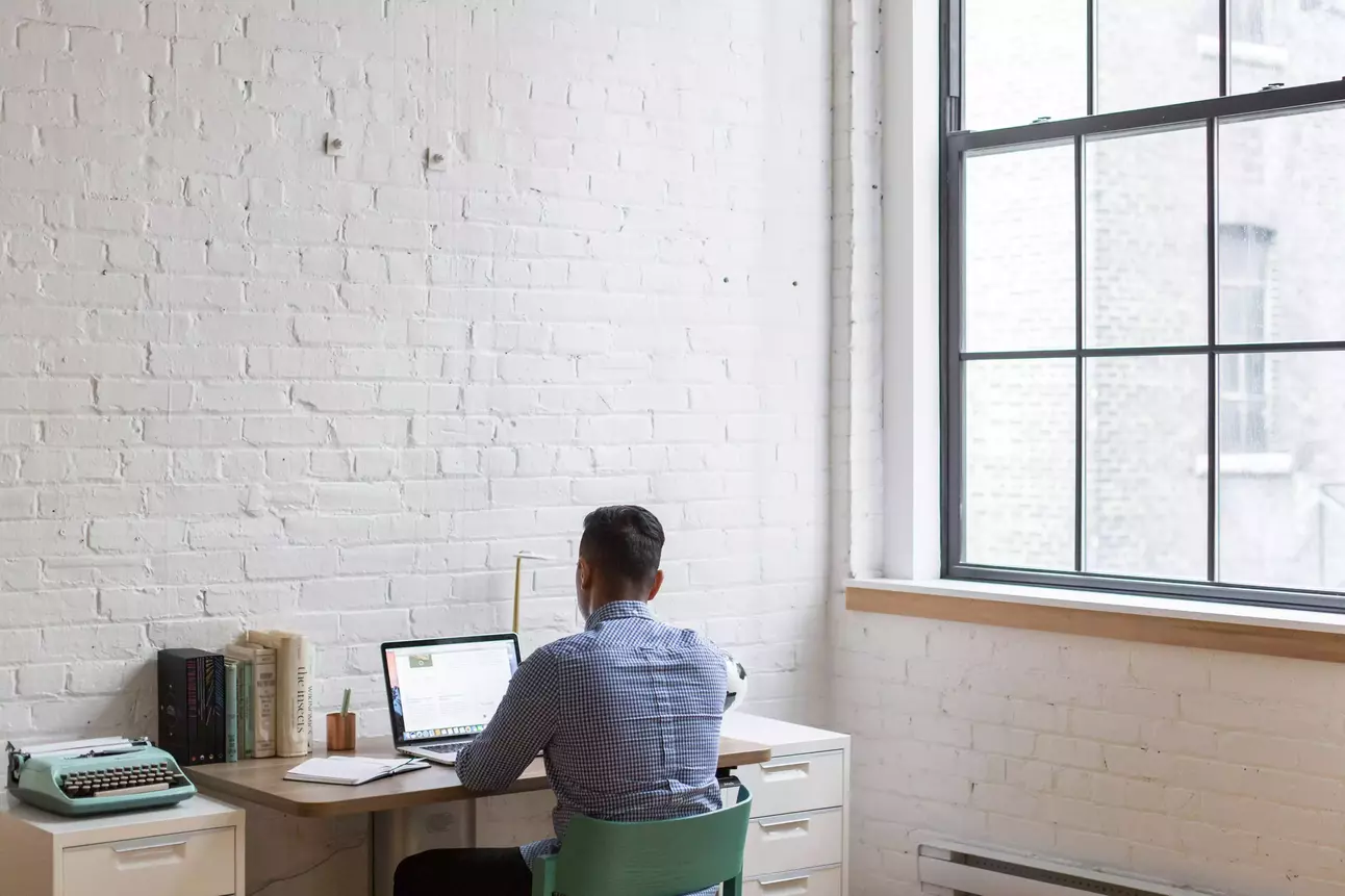 investisseur assis sur une chaise de bureau faisant des recherche sur son ordinateur sur la réglementation du private equity
