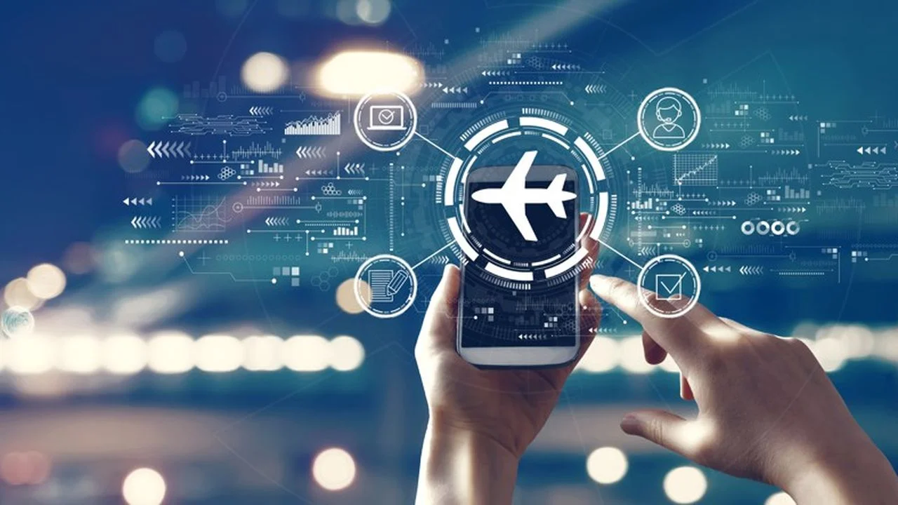 Deux mains utilisant un smartphone affichant une icône d'avion entourée d'éléments graphiques numériques, symbolisant l'investissement dans les technologies du secteur du voyage (traveltech).