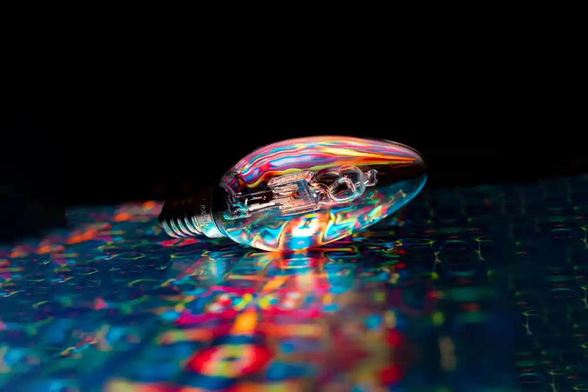 Ampoule sur carte mère avec reflets multicolores : illustration de l'innovation en IA et de la deep tech