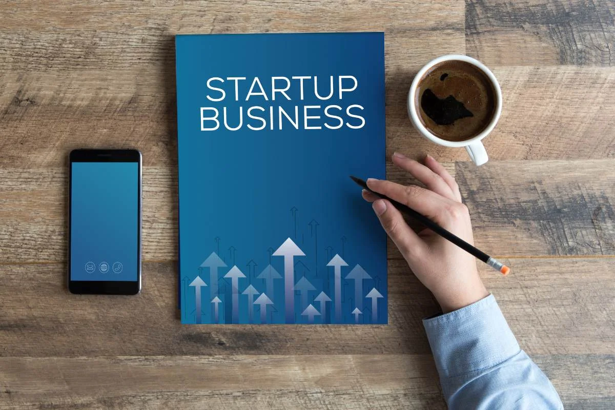 photo d'une main posée sur un cahier pour monter son business