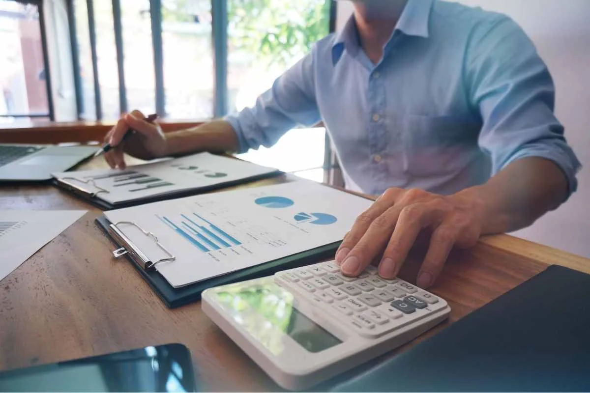 personne devant des feuilles et des graphiques pour savoir combien de pea détenir