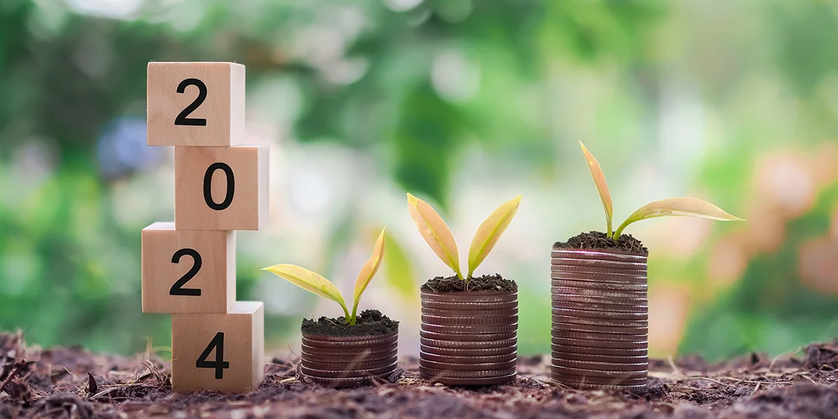Des cubes avec "2024" et des plantes sur des pièces de monnaie illustrent l'investissement croissant en 2024.