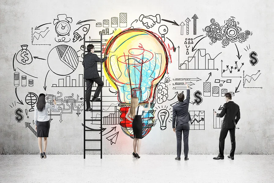 Des personnes dessinent une ampoule géante entourée de symboles de finance et d'innovation sur un mur, évoquant le concept de retailtech.
