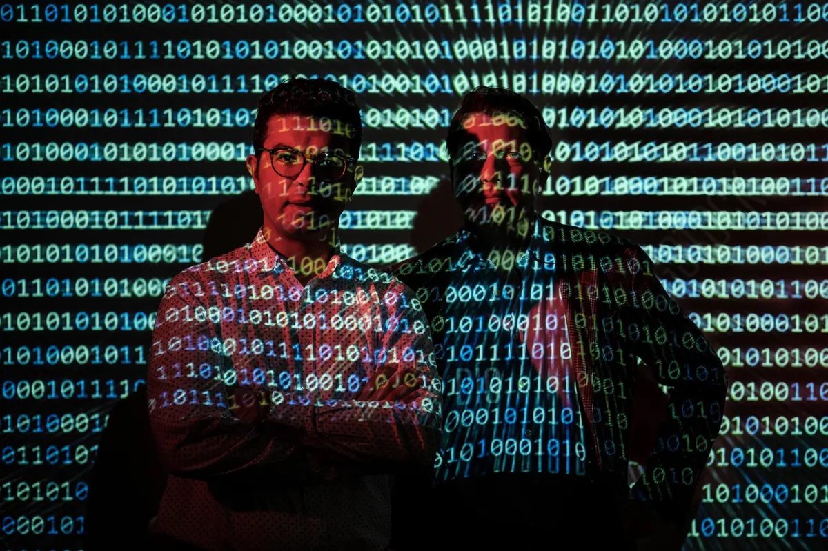 Deux personnes devant un écran affichant des lignes de code, illustrant les startups de cybersécurité et les investissements dans ce secteur.