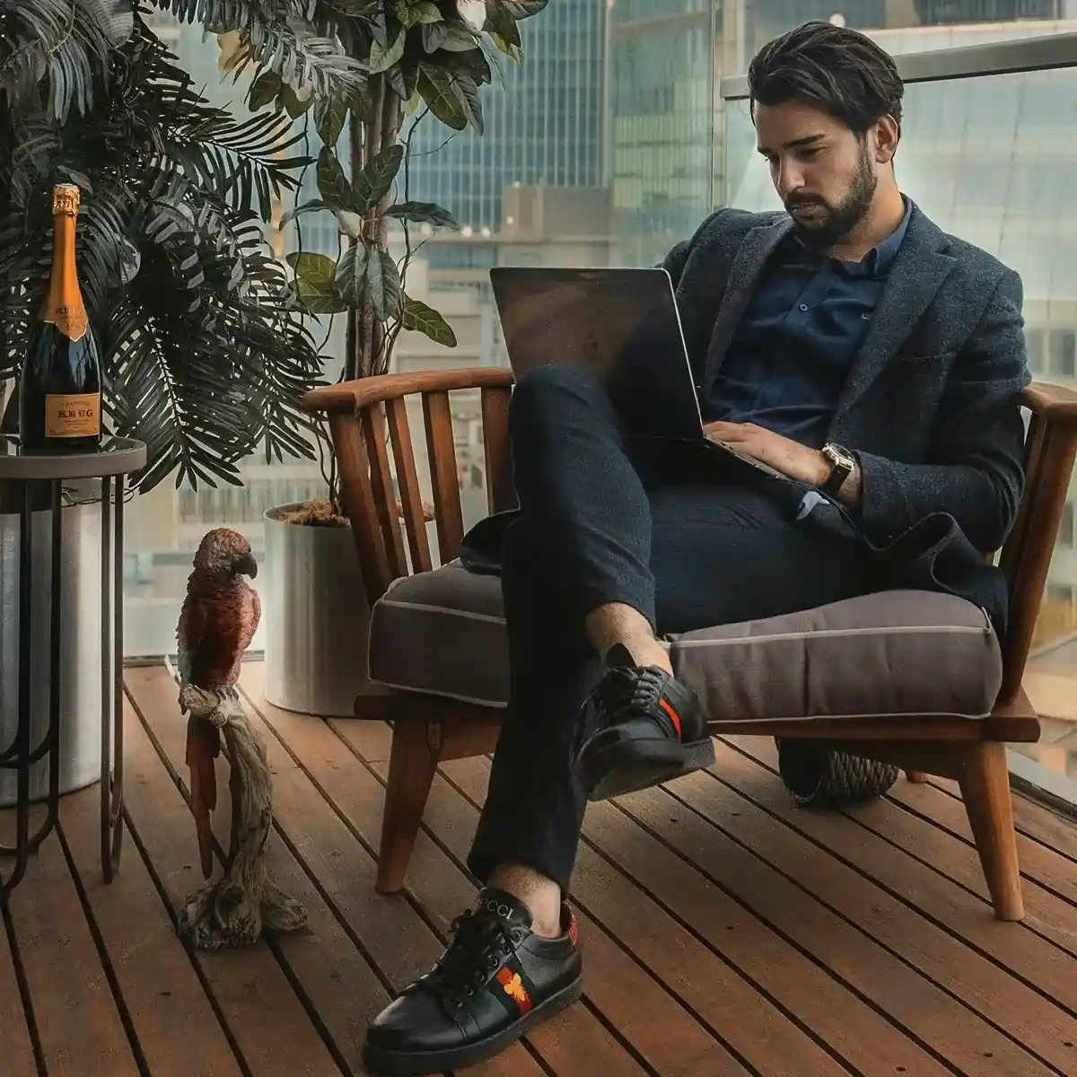 Jeune homme riche avec un peroquet et une bouteille de champagne