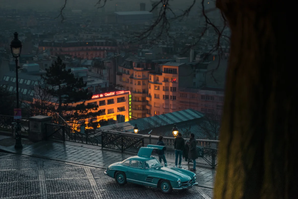 Illustration de la réussite parisienne : Voiture vintage de luxe sur rue pavée avec vue sur Paris.