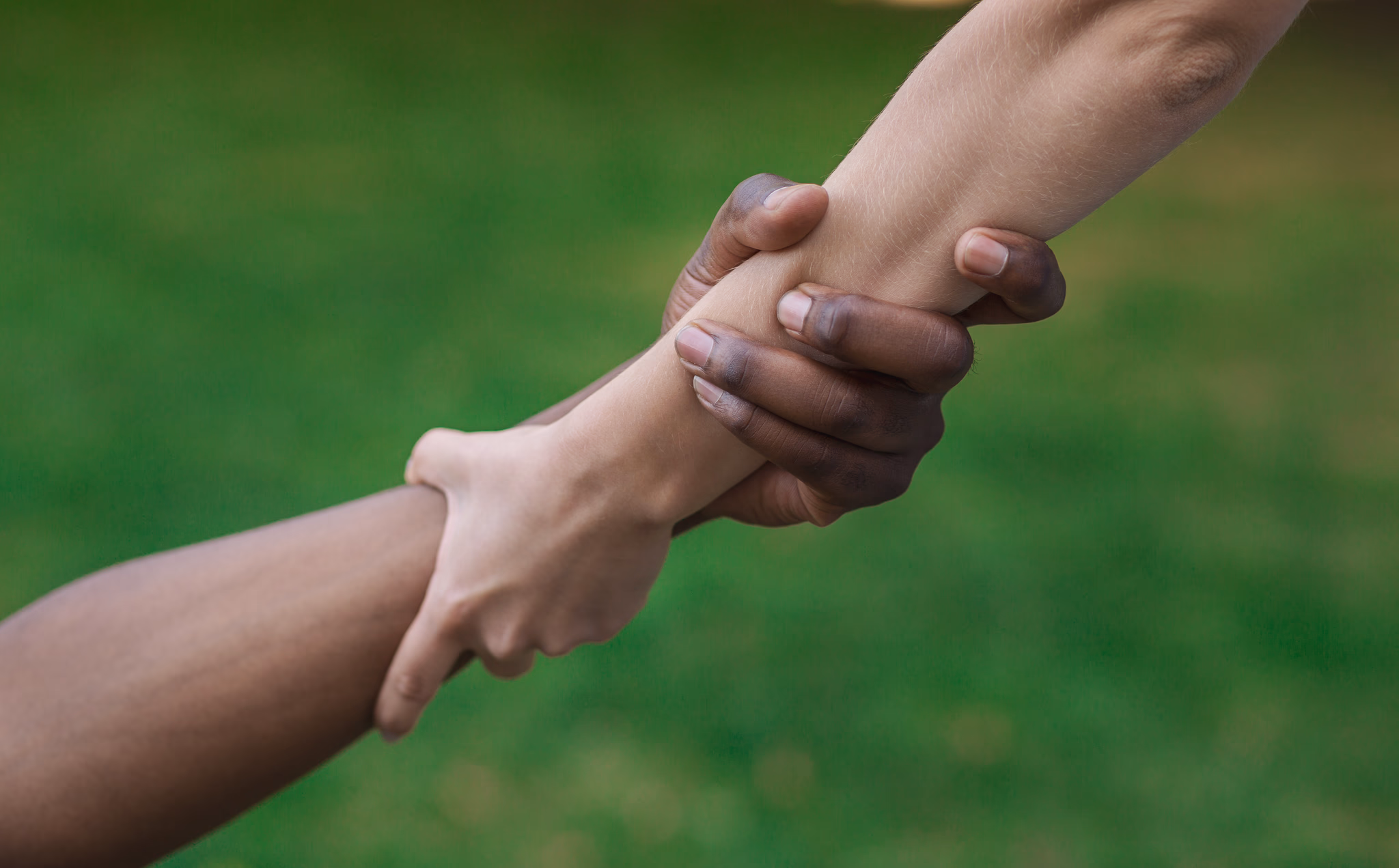 two arms reaching out and grasping eachother.