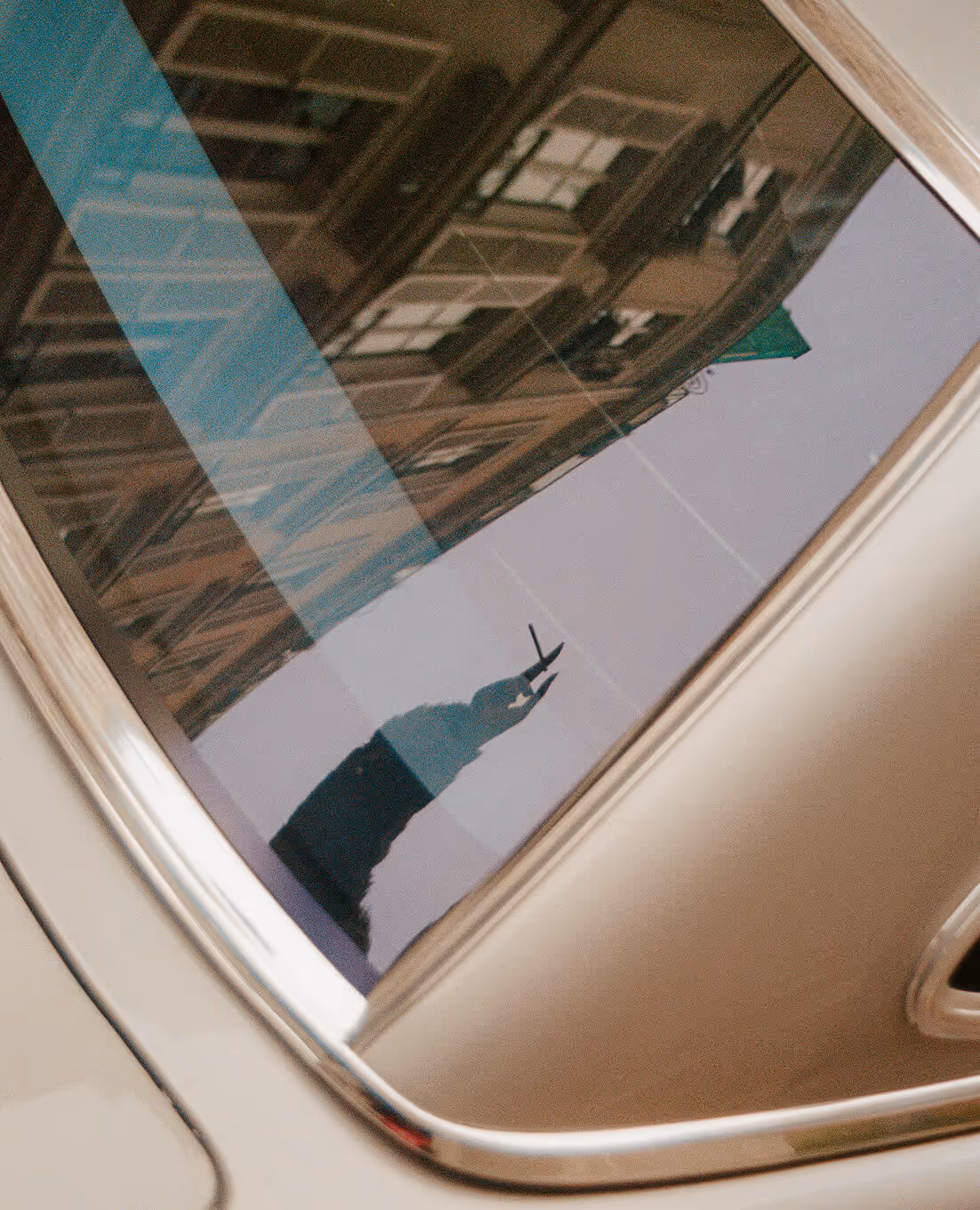 Reflet de la statue de la Liberté et d'un bâtiment sur la fenêtre d'une voiture blanche. - Hôtel Madison