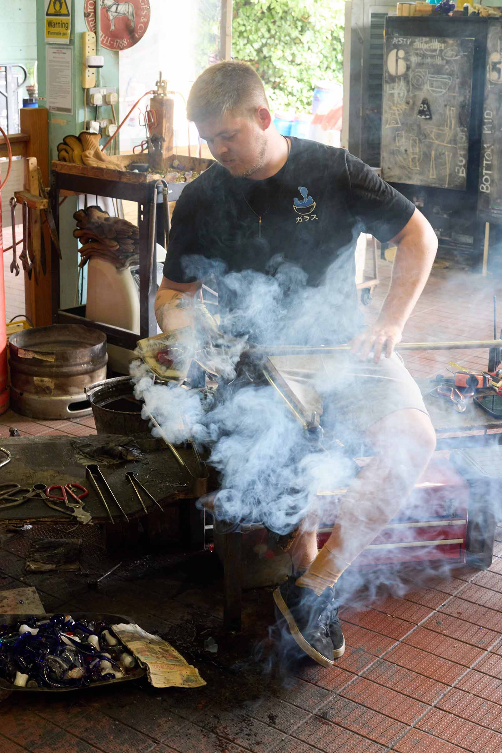 man working with molten glass including steam at bristol blue glass