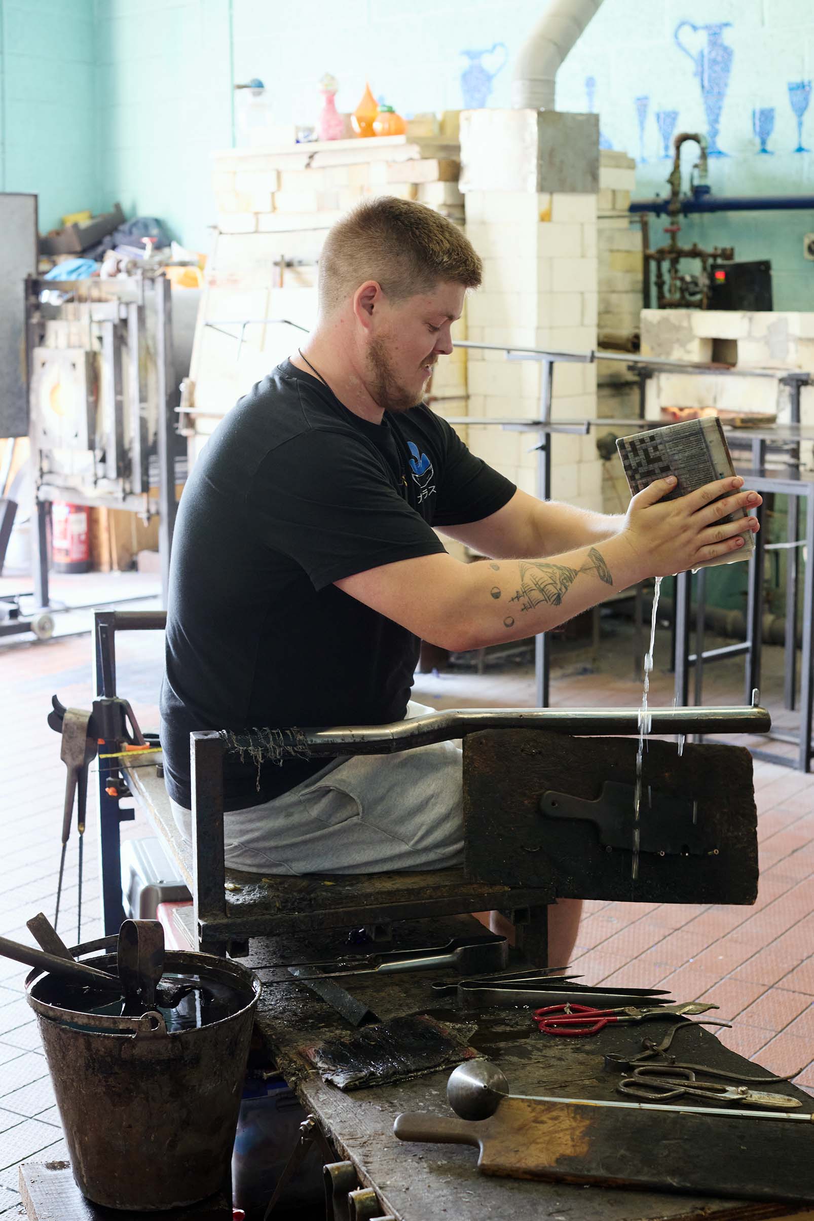man seated working at bristol blue glass