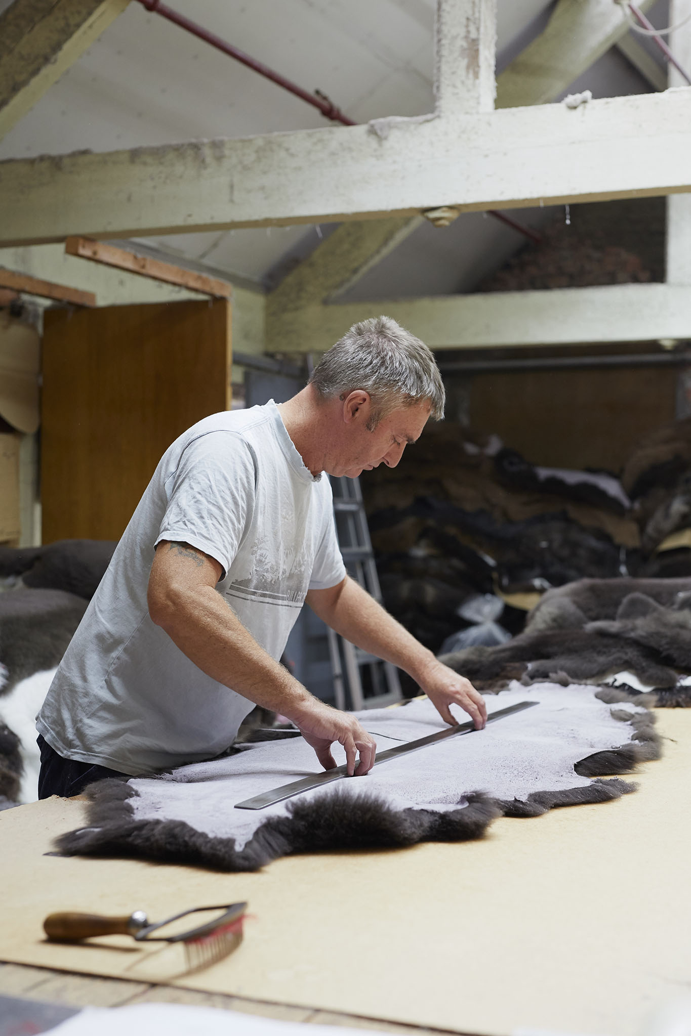 man at table measuring sheepskin devonia