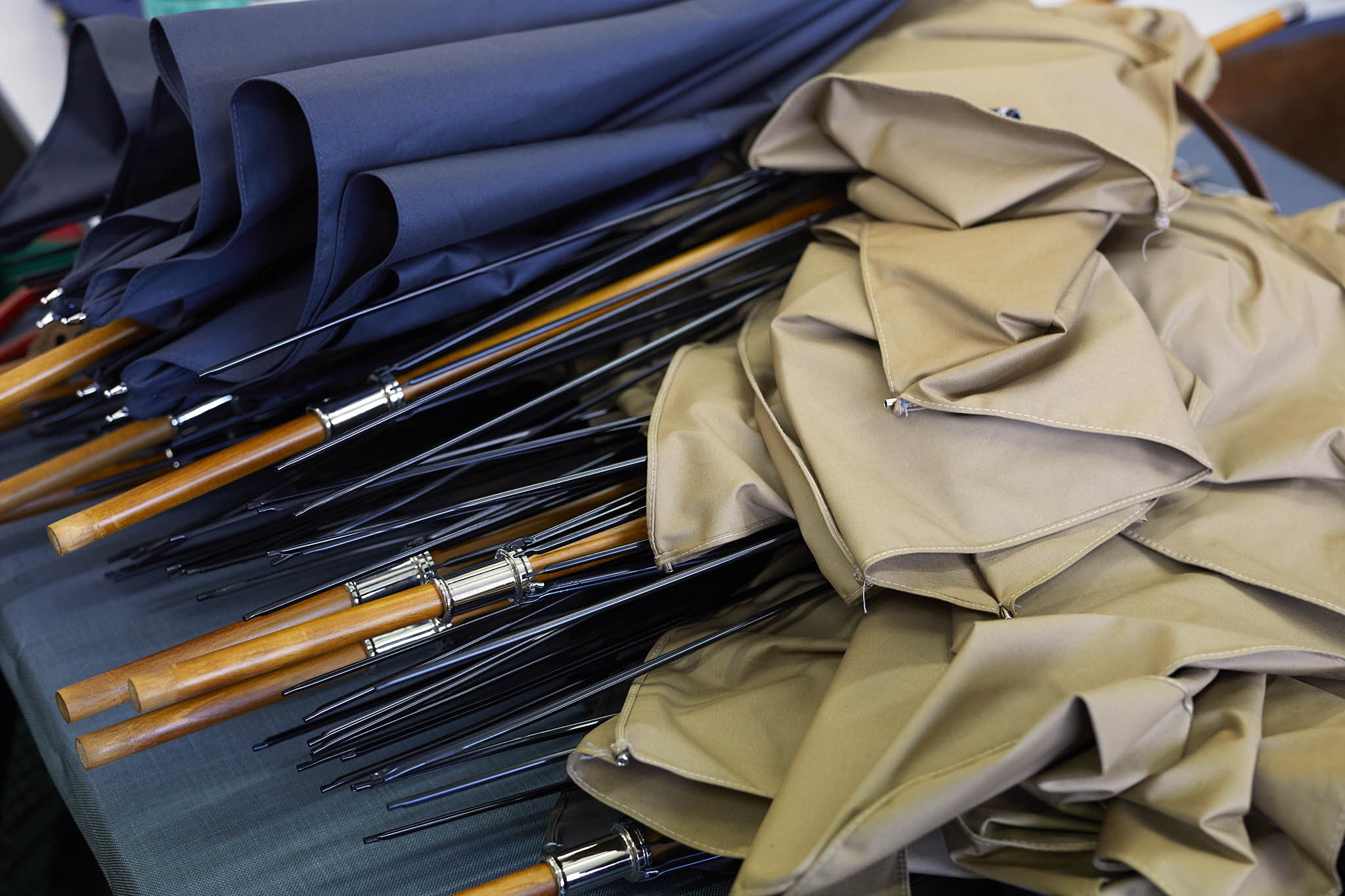 partially completed umbrellas stacked on table Ince Umbrellas