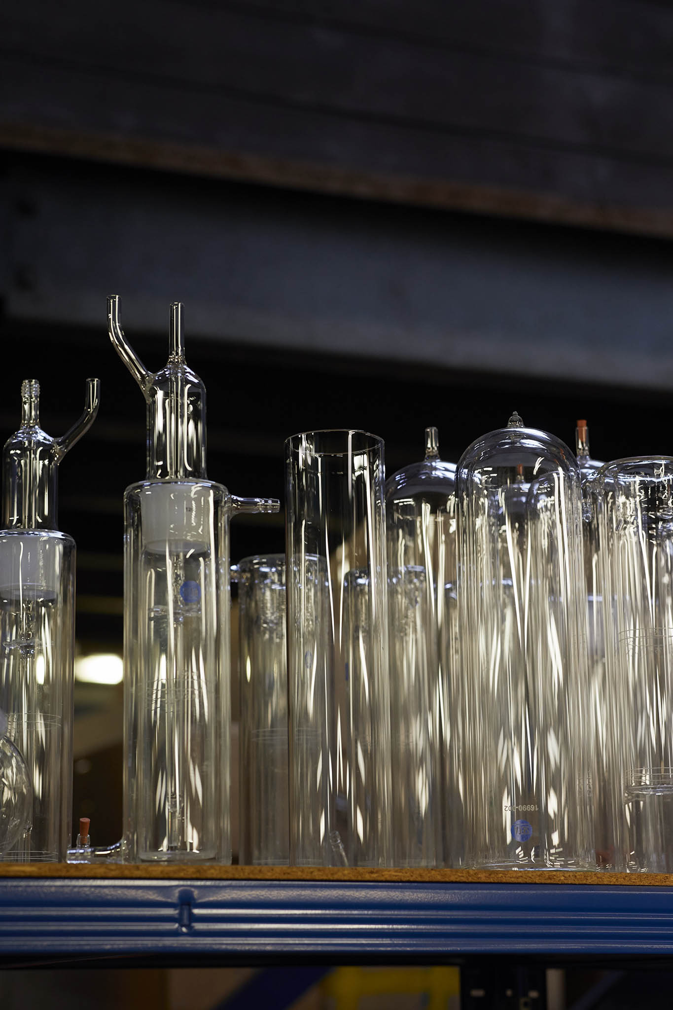 aimer products blue shelf of clear glass bottles and tubes of varying size