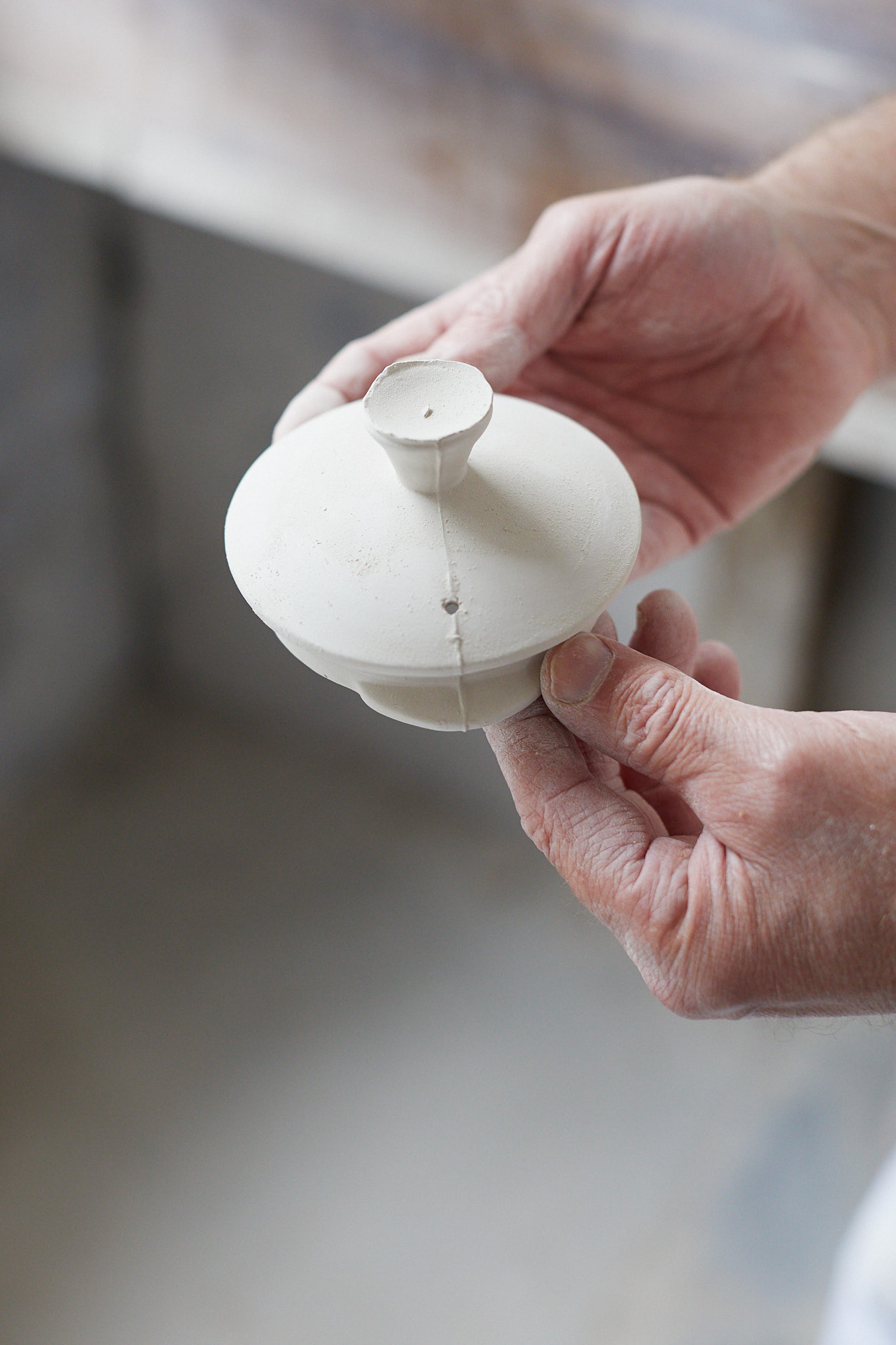 Burleigh pottery close up of hands with unfinished tea pot lid 