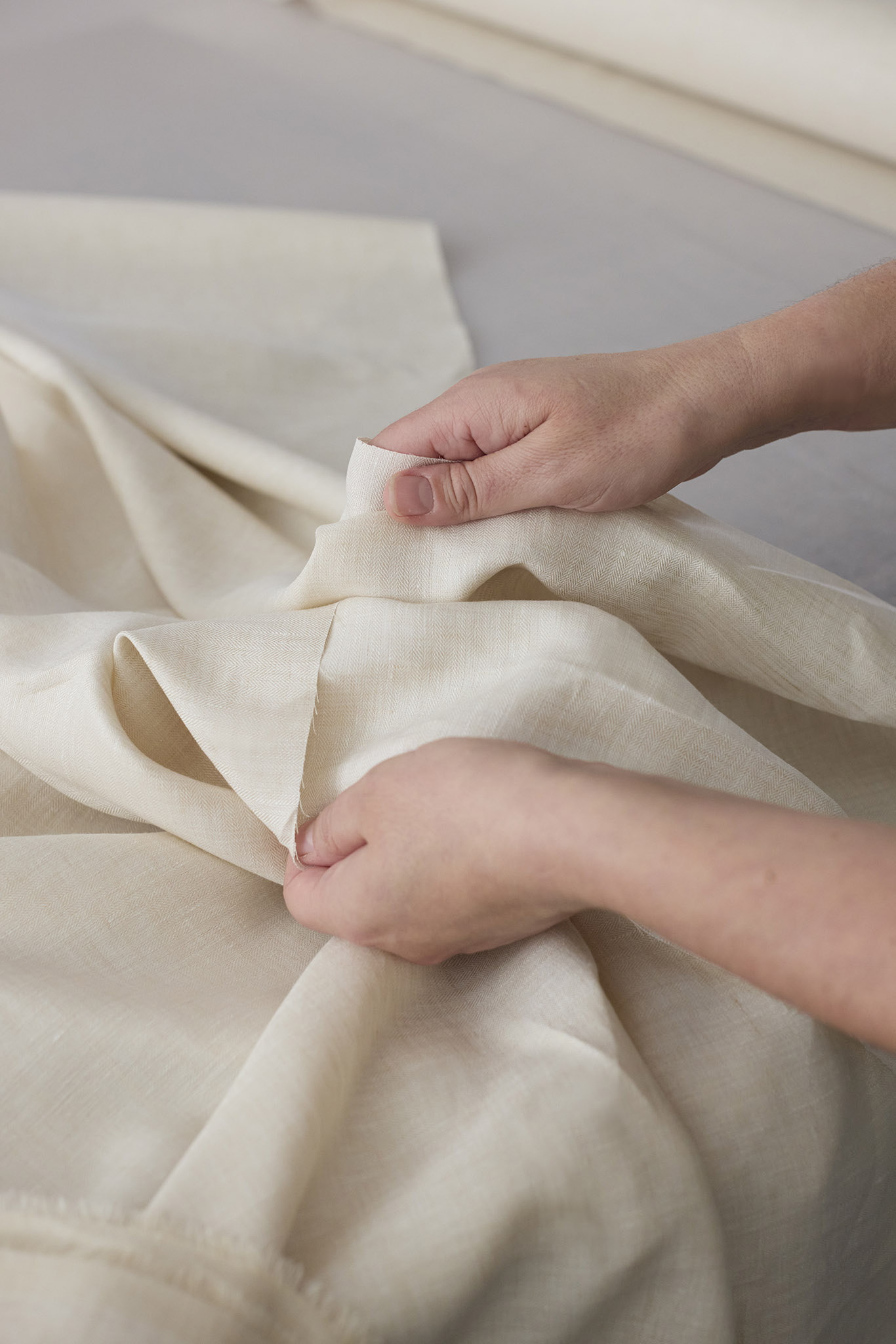 Emma Willis bespoke tailoring close up of hands with white cream ecru material