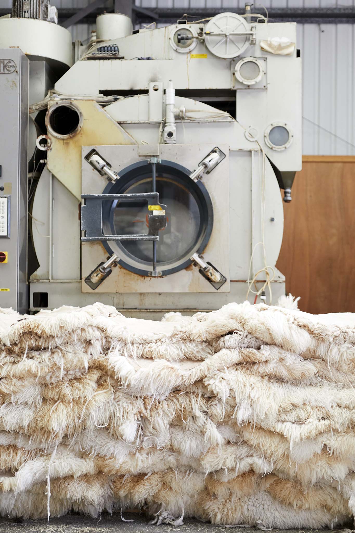 large pile of of sheepskins in front of factory machinery  devonia