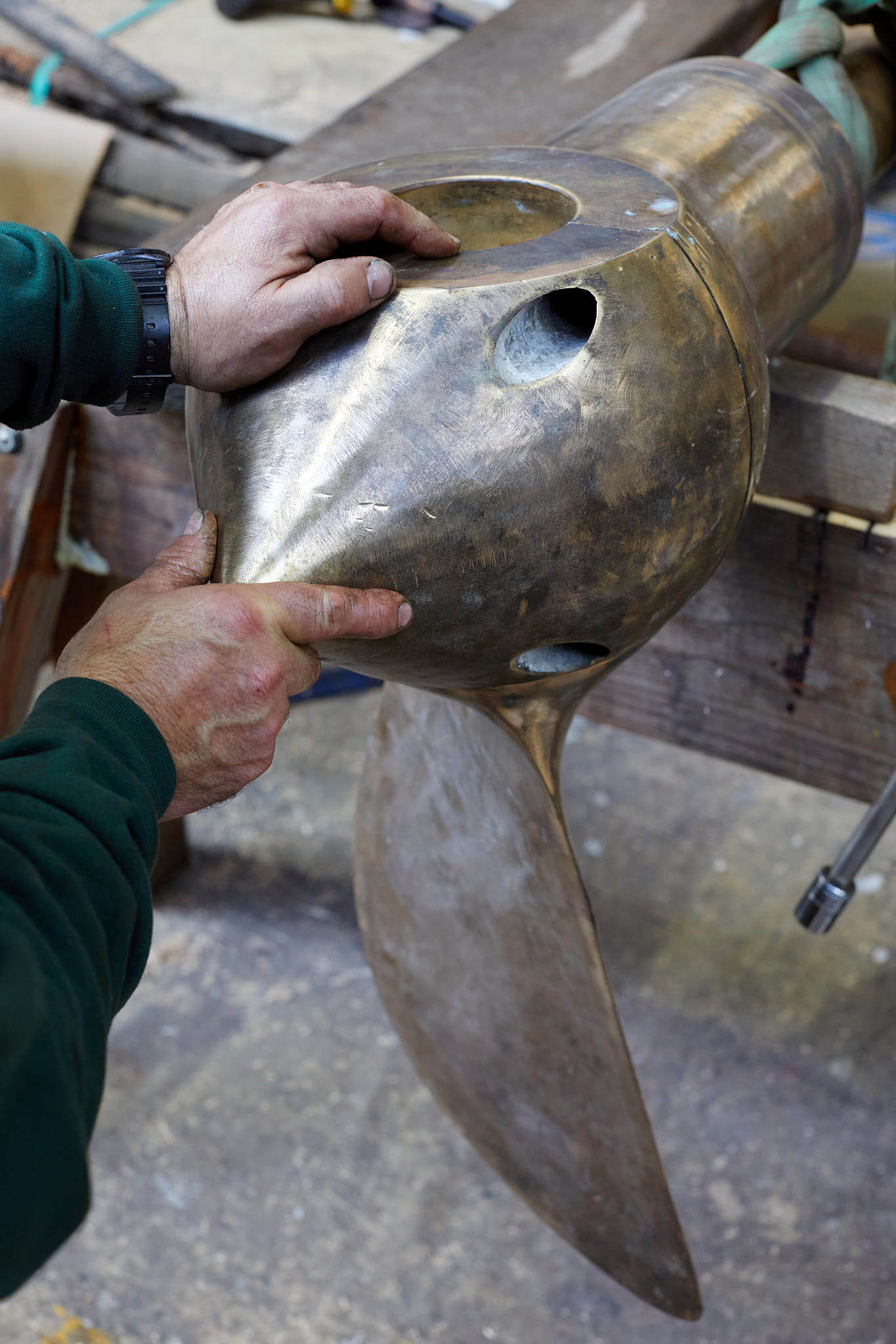 T Nielsen and Co close up of hands working on large ship propeller 