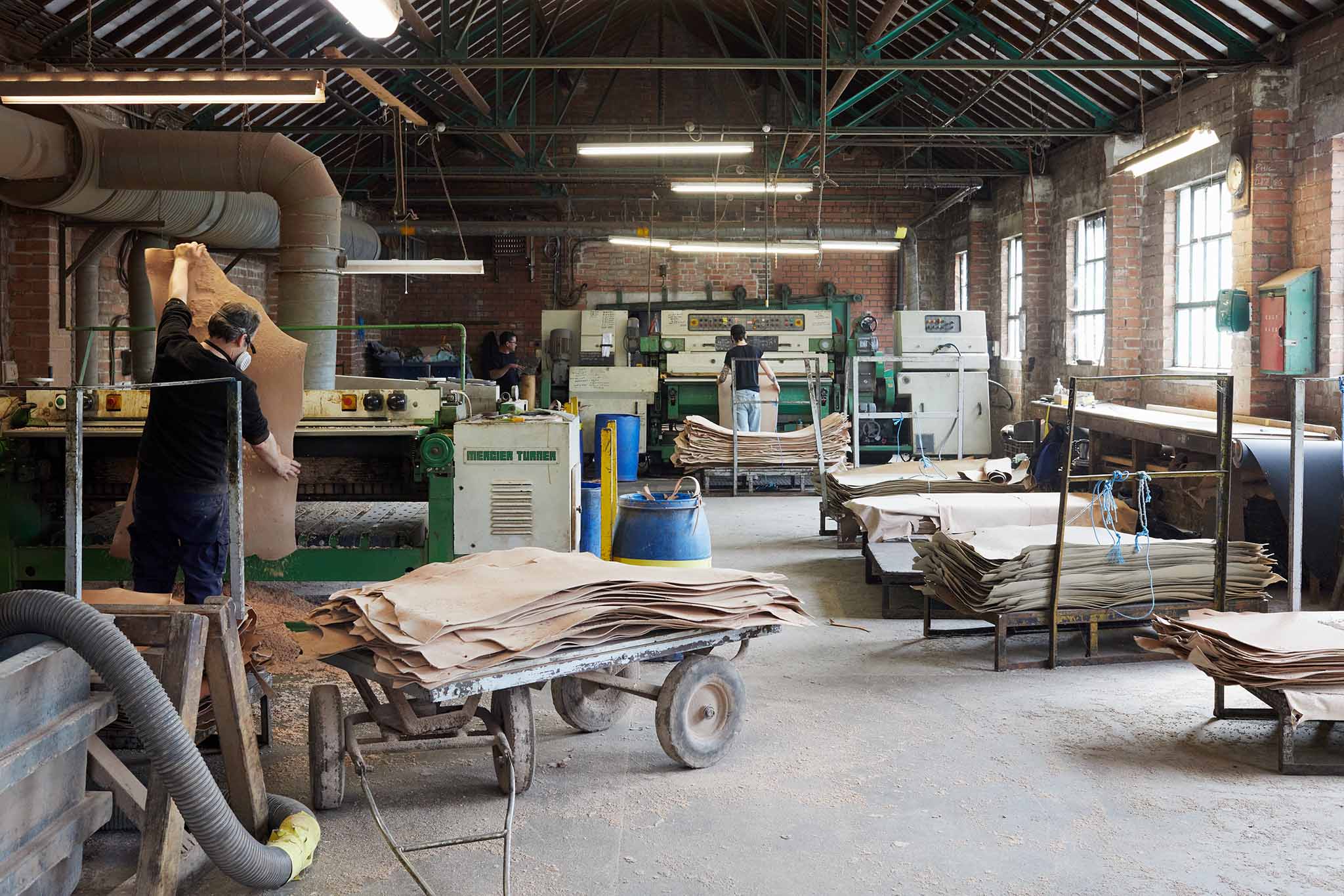 Thomas Ware and Sons worker inside leather factory piles of leather 