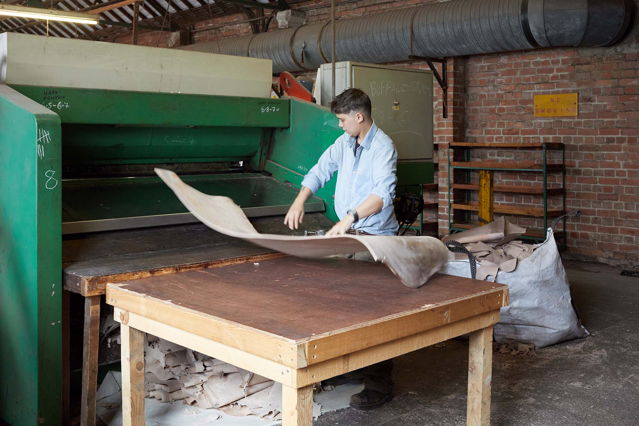 Thomas Ware and Sons worker in leather factory at table with leather