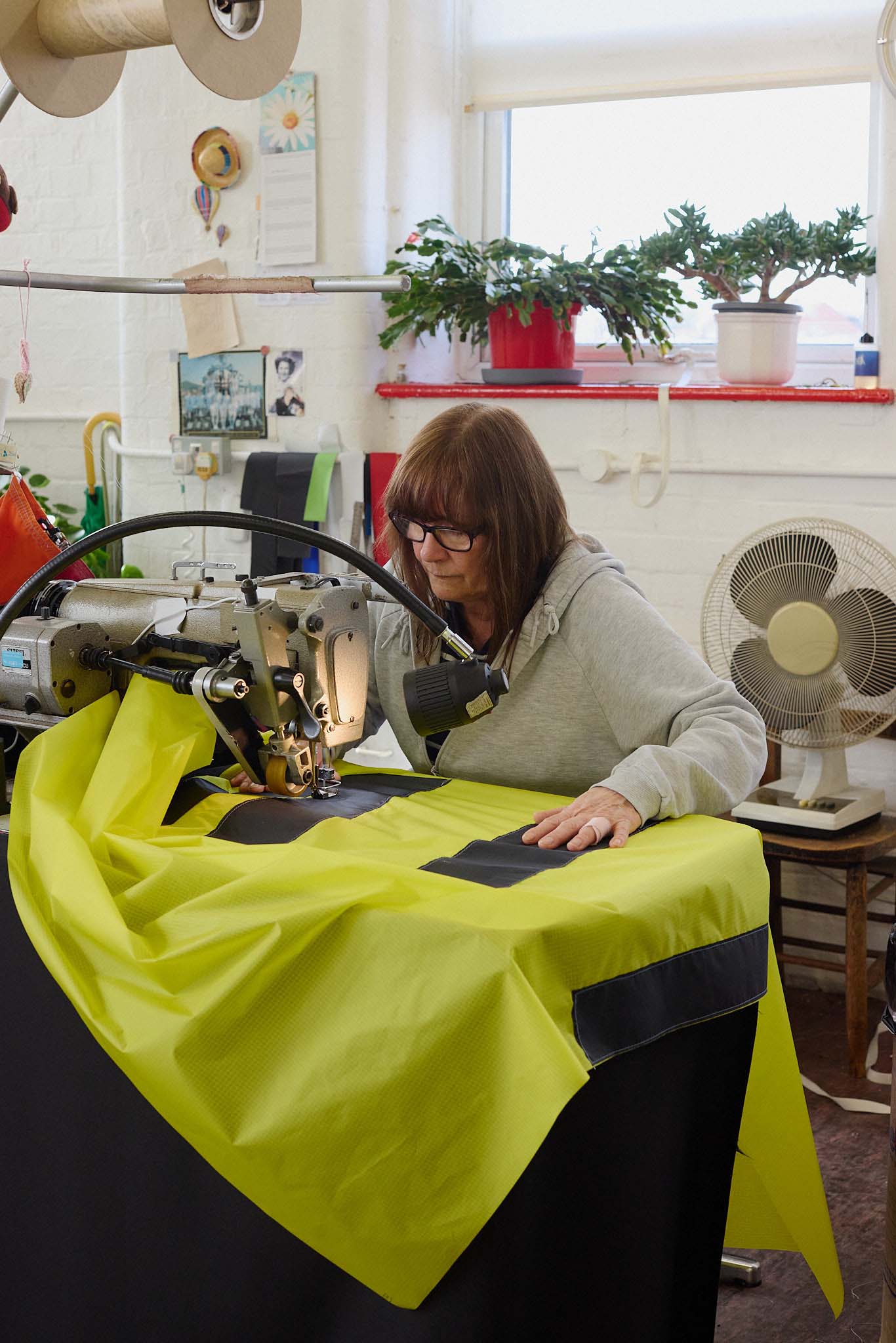 Cameron Balloons female seamstress at sewing machine working on yellow hot air balloon