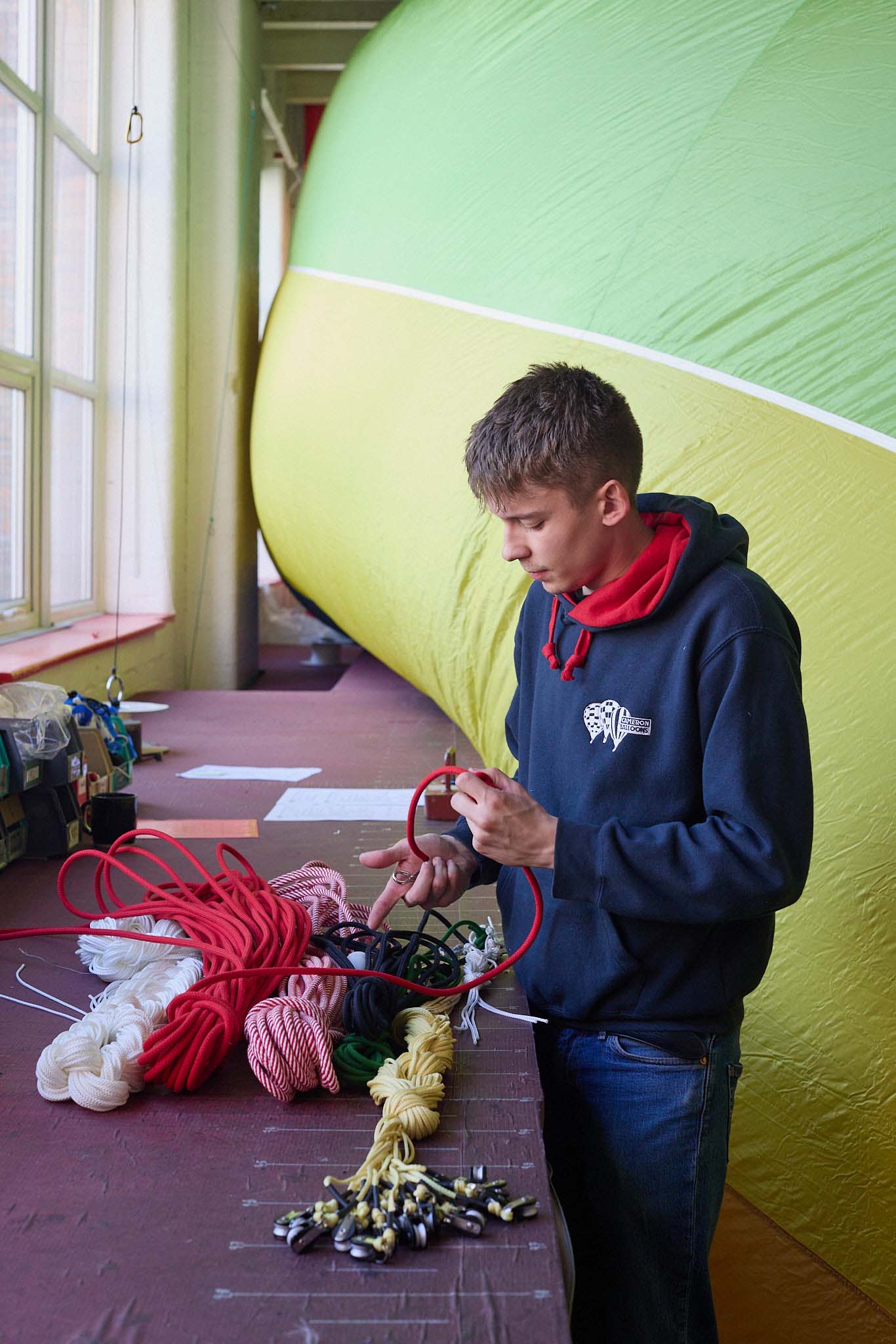 Cameron Balloons young man standing in front of partially inflated balloon and coloured rope