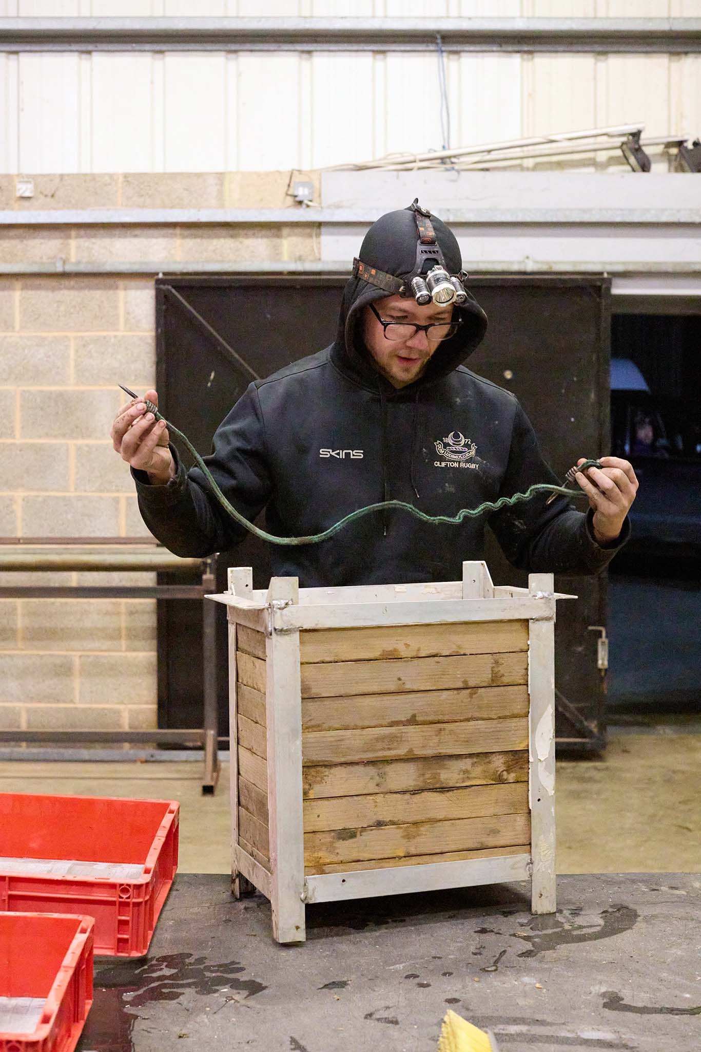 uk glass eels man in waterproof clothing and head torch using equipment 