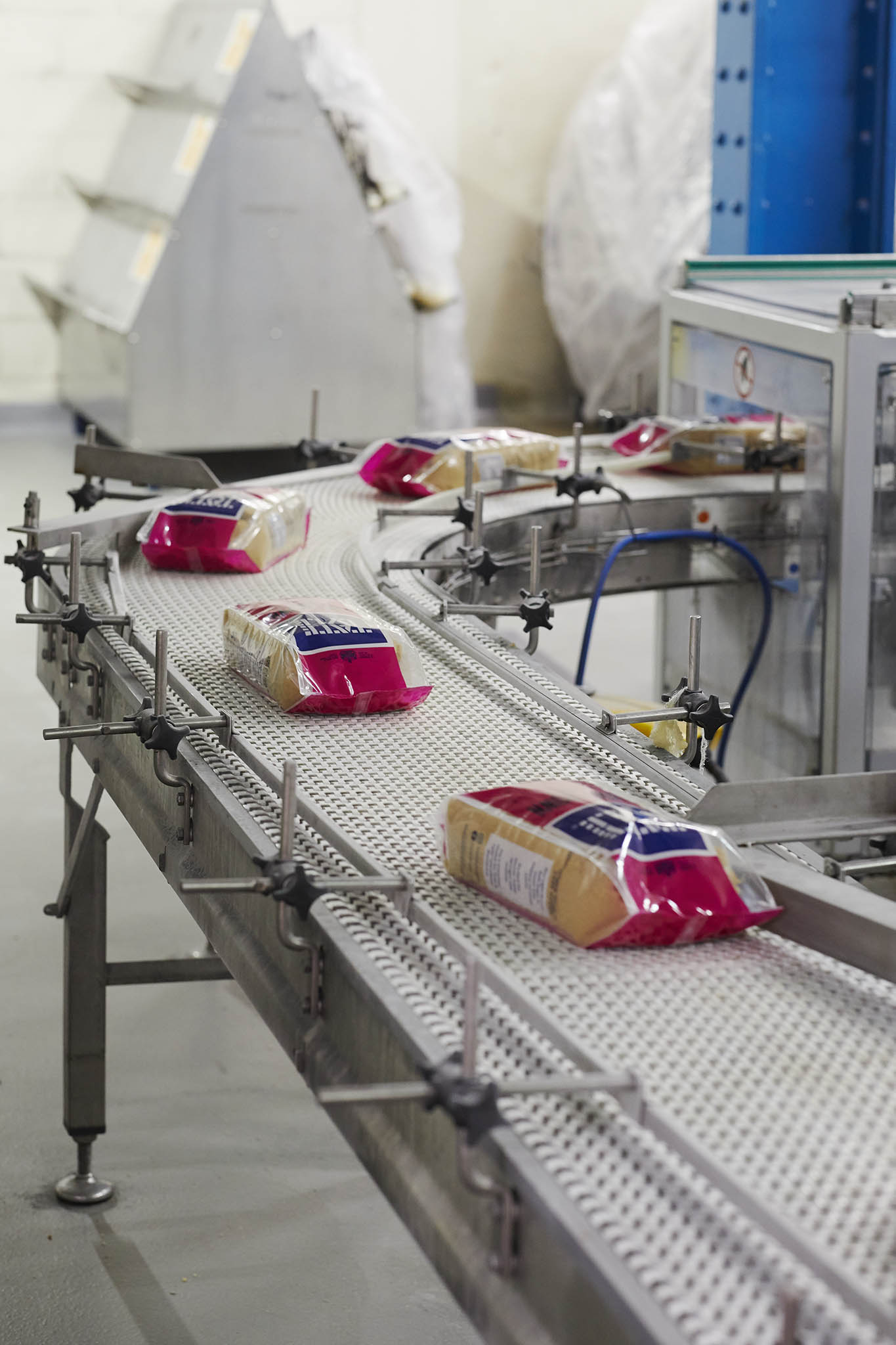 Tate and Lyle Sugars inside factory red and orange packets of sugar on conveyor belt